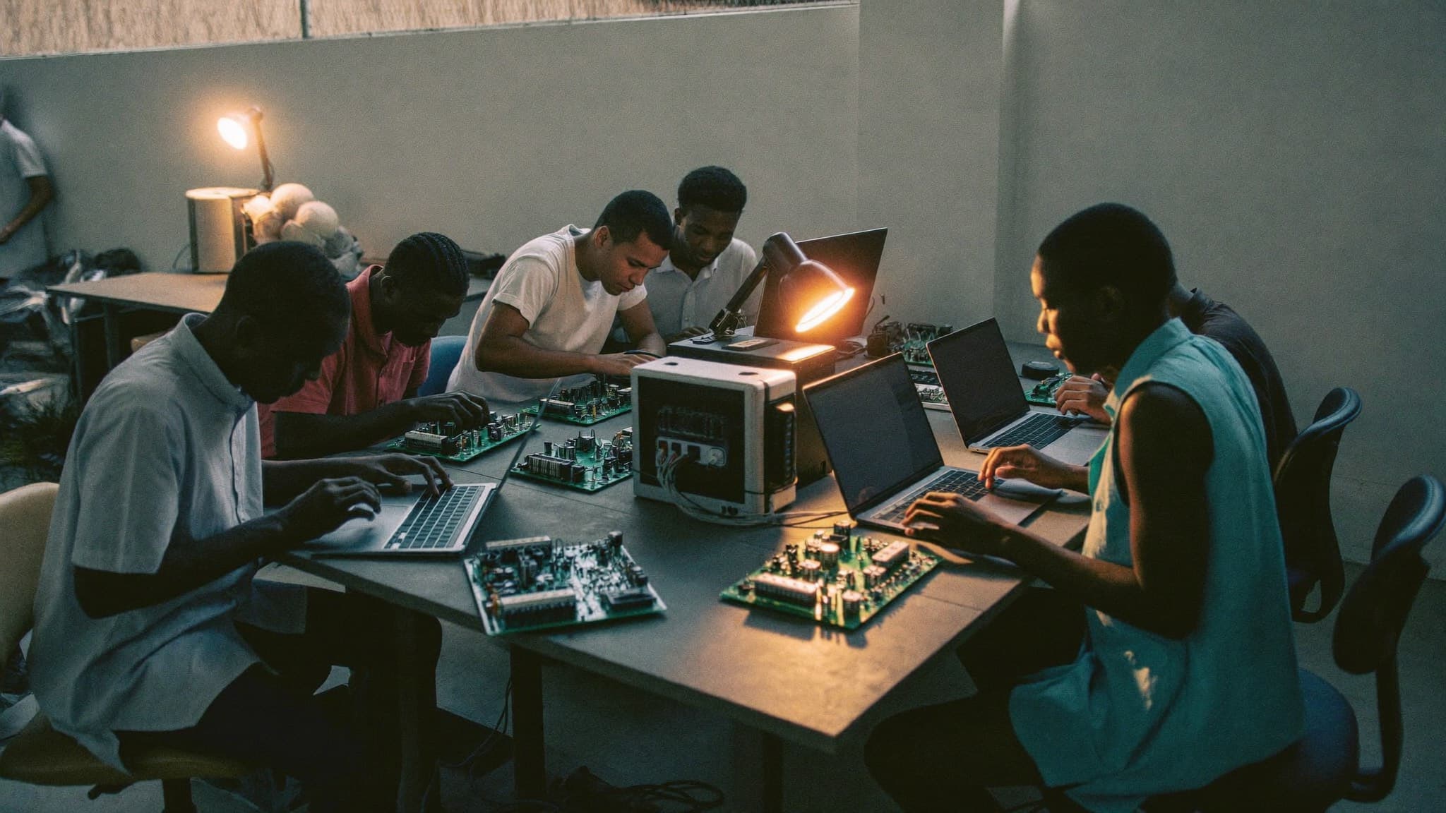 Engineers testing controller boards on a workshop bench