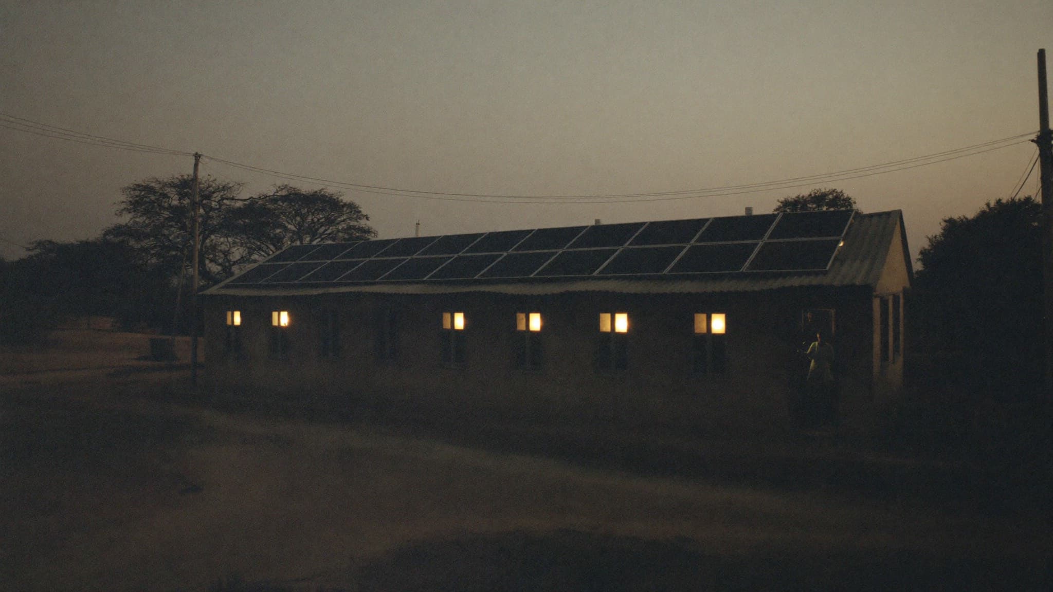 Rural health clinic with solar panels on its roof at dusk