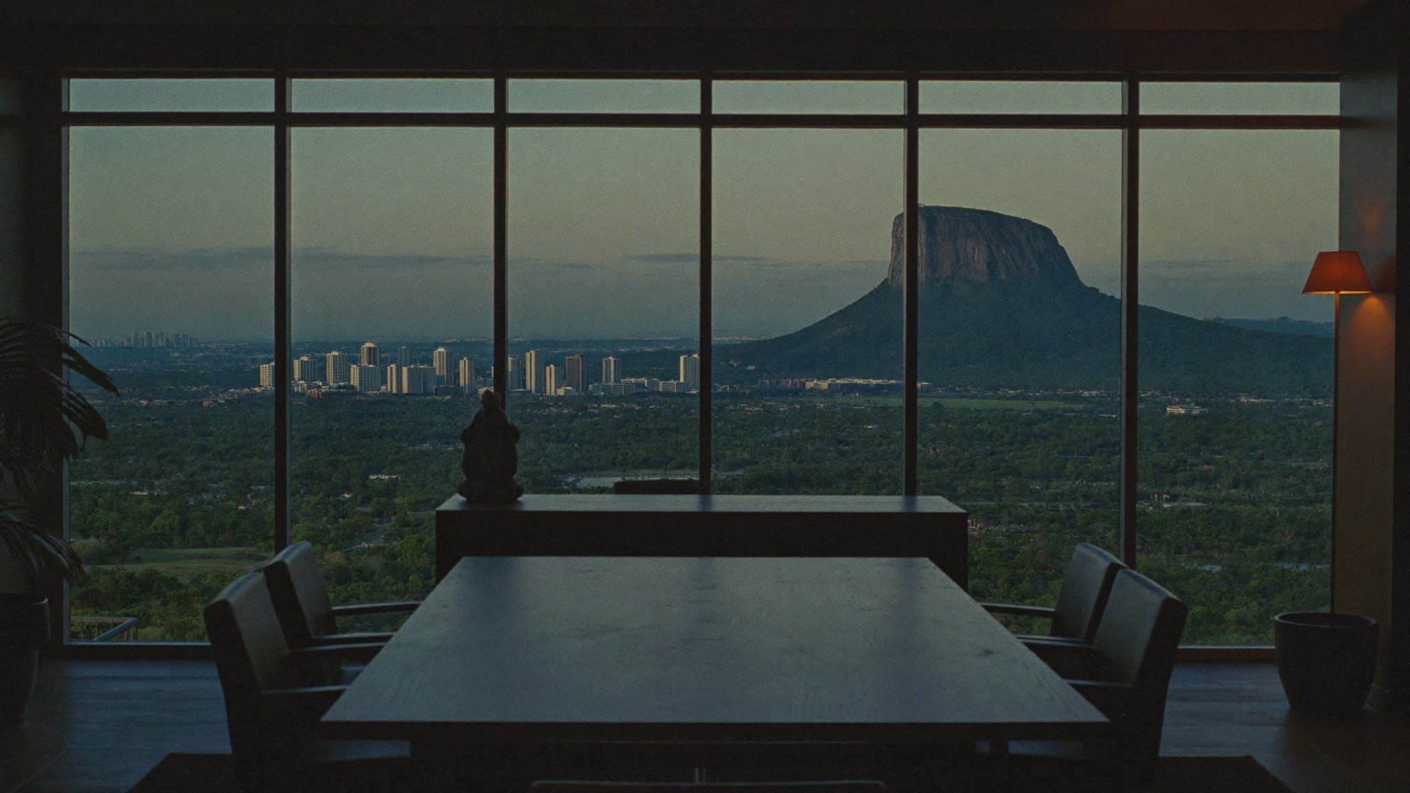 Meeting room at dusk overlooking a green city and a rock monolith in Abuja