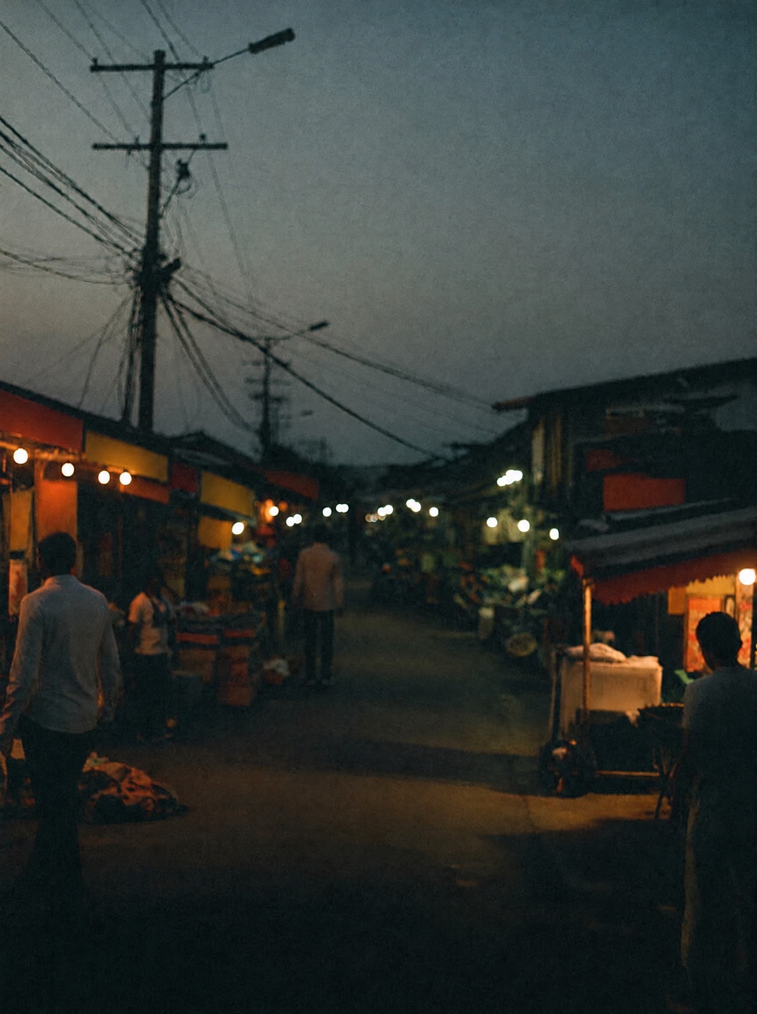Neighbourhood market street in Abuja lit by LED bulbs at dusk