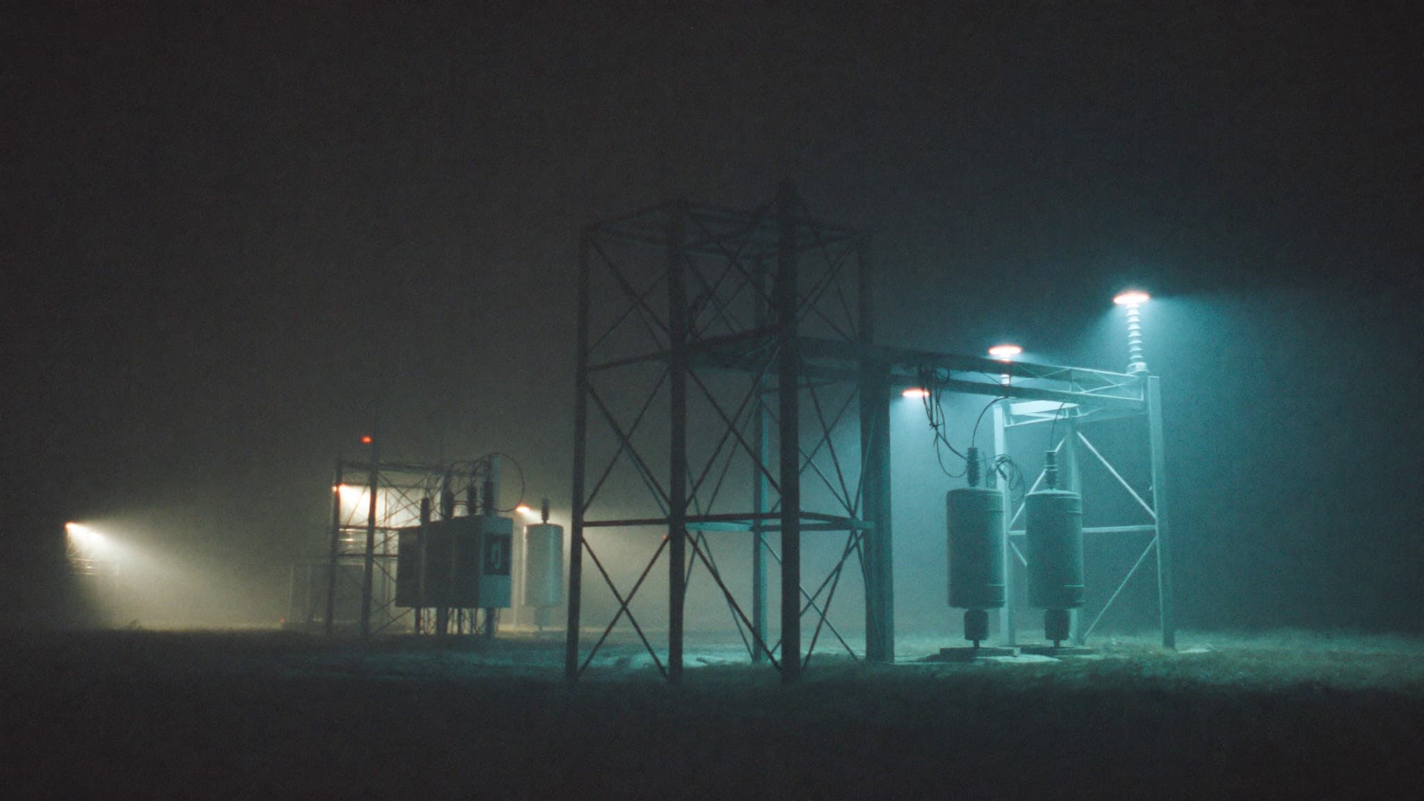 Electrical substation lit by blue floodlights at night