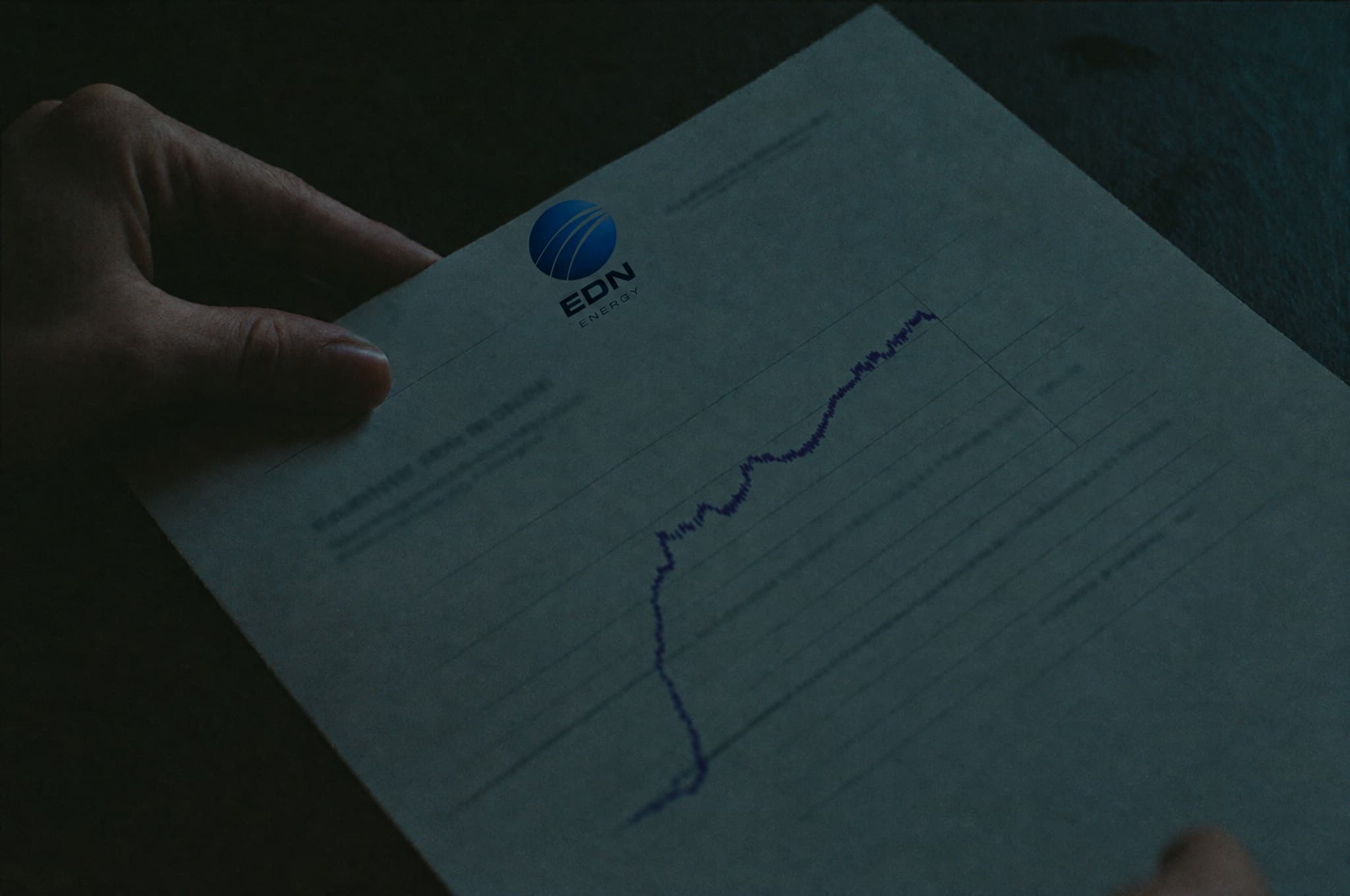 Hands leafing through a printed financial report with charts
