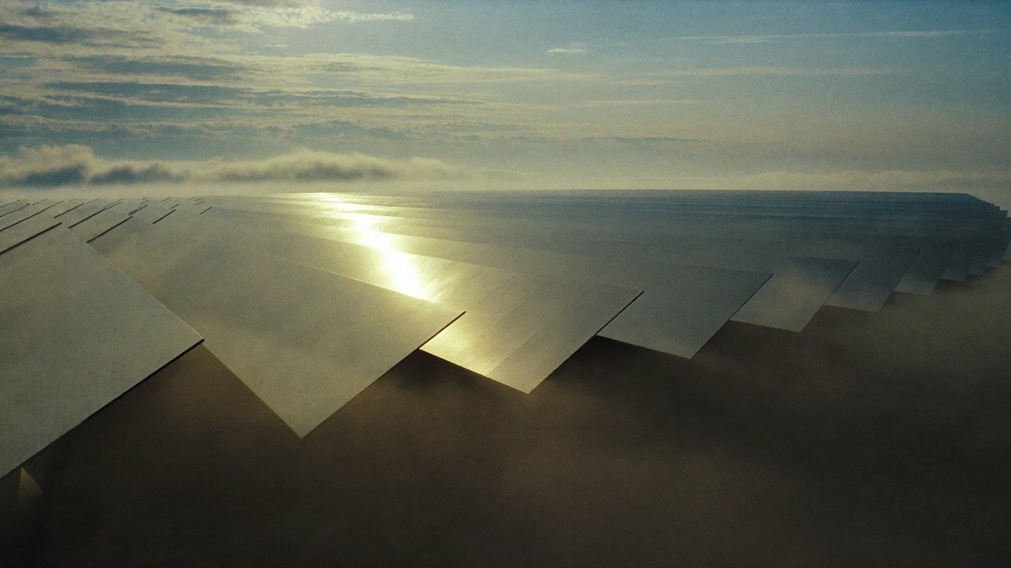 Solar field glowing at sunrise with low mist