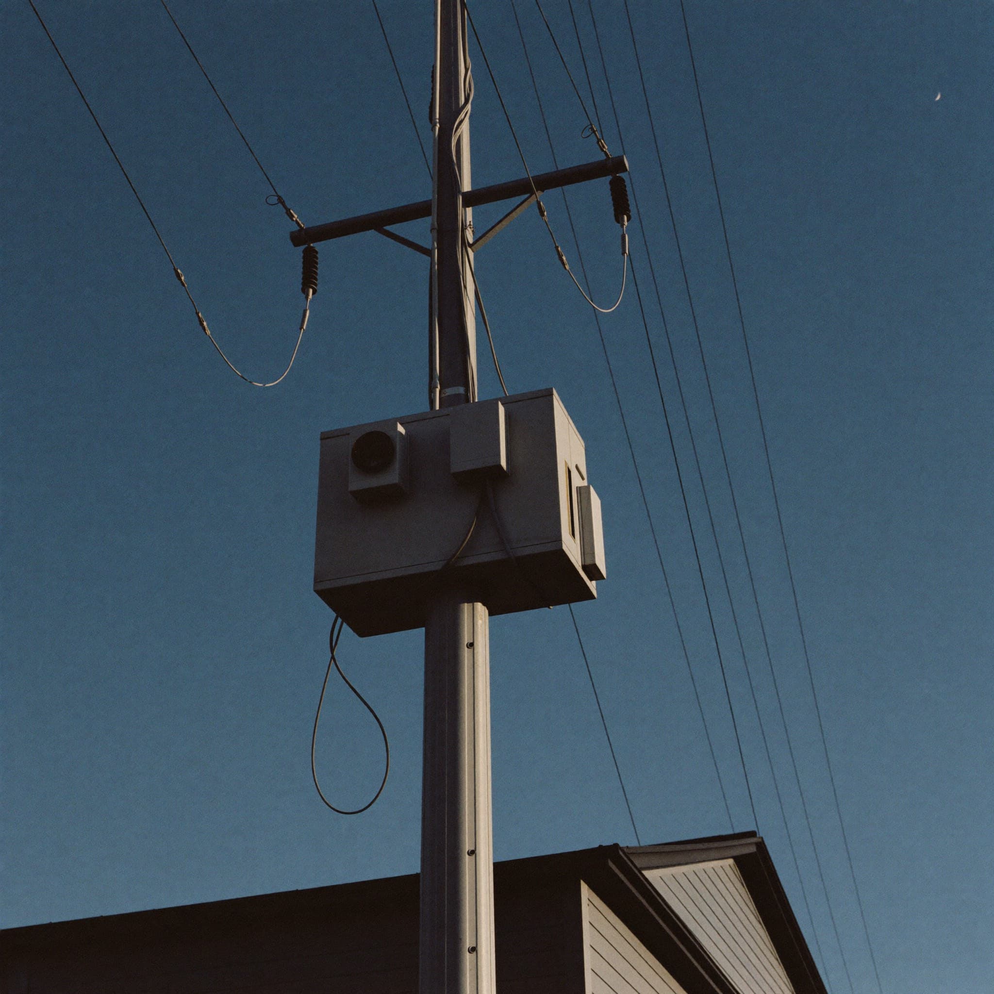 Pole-mounted distribution transformer against a dusk sky